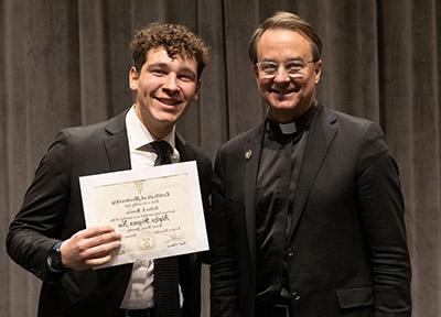 CJ Braccia with Father Hendrickson while receiving Sigma Nu certificate. 