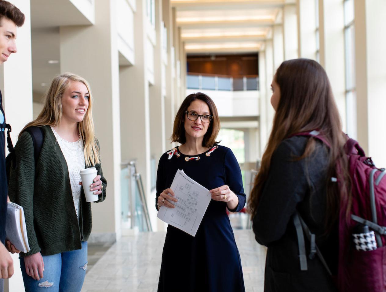 玛丽黛娜 Laird talking with students in Heider College of Business.