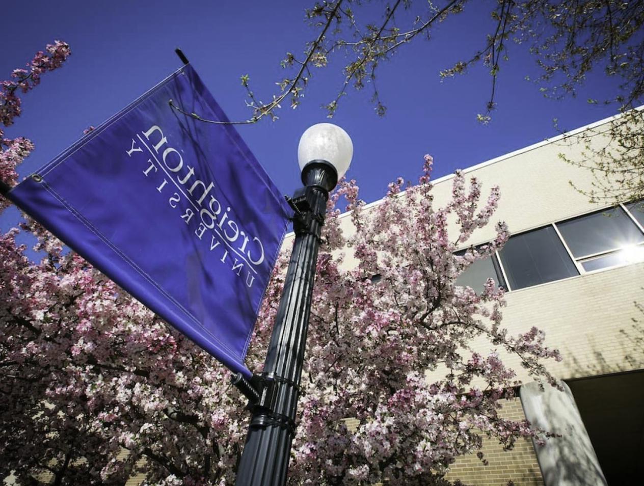 College of Law building with Creighton University banner outside on sunny day.